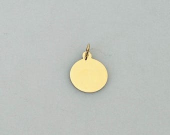 Puede incluir: Un colgante circular de oro liso con un pequeño bucle en la parte superior para sujetarlo a una cadena.
