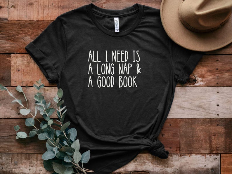 May include: Black t-shirt with white text that reads "All I need is a long nap & a good book".