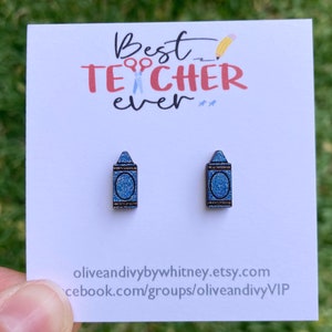 K&ouml;nnte beinhalten: Ein Paar blaue Glitzer-Kreide-Ohrringe auf einer wei&szlig;en Karte mit dem Text "Best Teacher Ever" und der Website-Adresse "oliveandivybywhitney.etsy.com" und "facebook.com/groups/oliveandivyVIP".