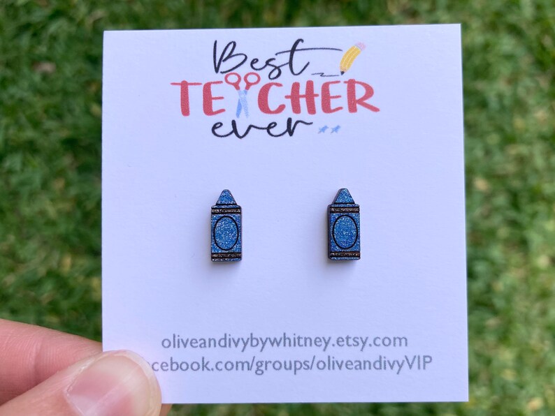 K&ouml;nnte beinhalten: Ein Paar blaue Glitzer-Kreide-Ohrringe auf einer wei&szlig;en Karte mit dem Text "Best Teacher Ever" und der Website-Adresse "oliveandivybywhitney.etsy.com" und "facebook.com/groups/oliveandivyVIP".