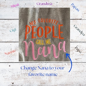 May include: A gray towel with embroidered text in orange and pink. The text reads "MY FAVORITE PEOPLE CALL ME Nana". Additional text at the bottom says "Change Nana to your favorite name".