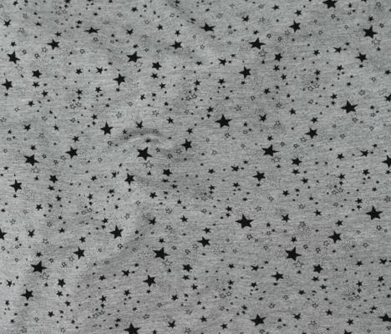 Puede incluir: Tela gris con un patr&oacute;n de estrellas negras. Las estrellas son de diferentes tama&ntilde;os y est&aacute;n dispersas aleatoriamente por la tela.