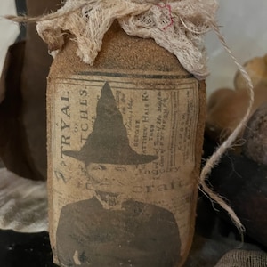 Op de afbeelding: Een bruine glazen pot met een jute-achtige textuur en een label met de tekst "Try All Twitches". De pot is bedekt met een stuk witte gaas en vastgebonden met touw.