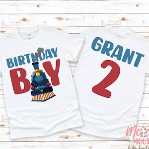 May include: White t-shirt with a blue train and the text "Birthday Boy" in red. The back of the shirt has the name "Grant" and the number "2" in red.