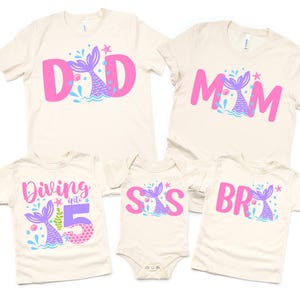 May include: Set of five t-shirts with a mermaid theme. The shirts feature the words "Dad", "Mom", "Sis", "Bro", and "Diving into 5". The shirts are all white with pink and purple lettering and a mermaid tail graphic.