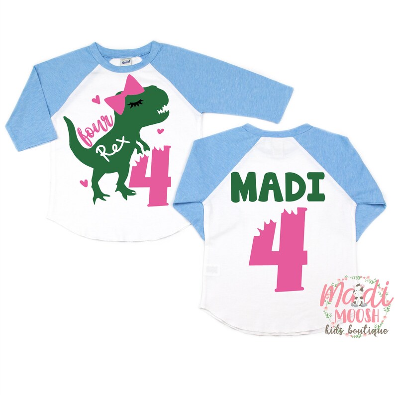 May include: A white and light blue baseball tee shirt with a green dinosaur wearing a pink bow and the text "four Rex" and the number "4" in pink. The back of the shirt has the name "MADI" in green and the number "4" in pink.