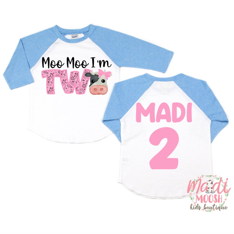 May include: Two-piece baby baseball tee shirt set with a cow and the words "Moo Moo I'm Two" on the front and the name "MADI" and the number "2" on the back. The shirt is blue and white.