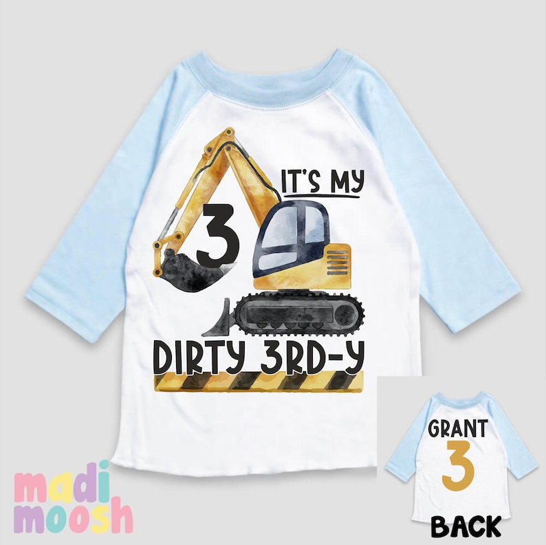 May include: A white and blue raglan t-shirt with a yellow excavator graphic and the text "It's my dirty 3rd-y". The back of the shirt has the text "Grant 3" in gold.