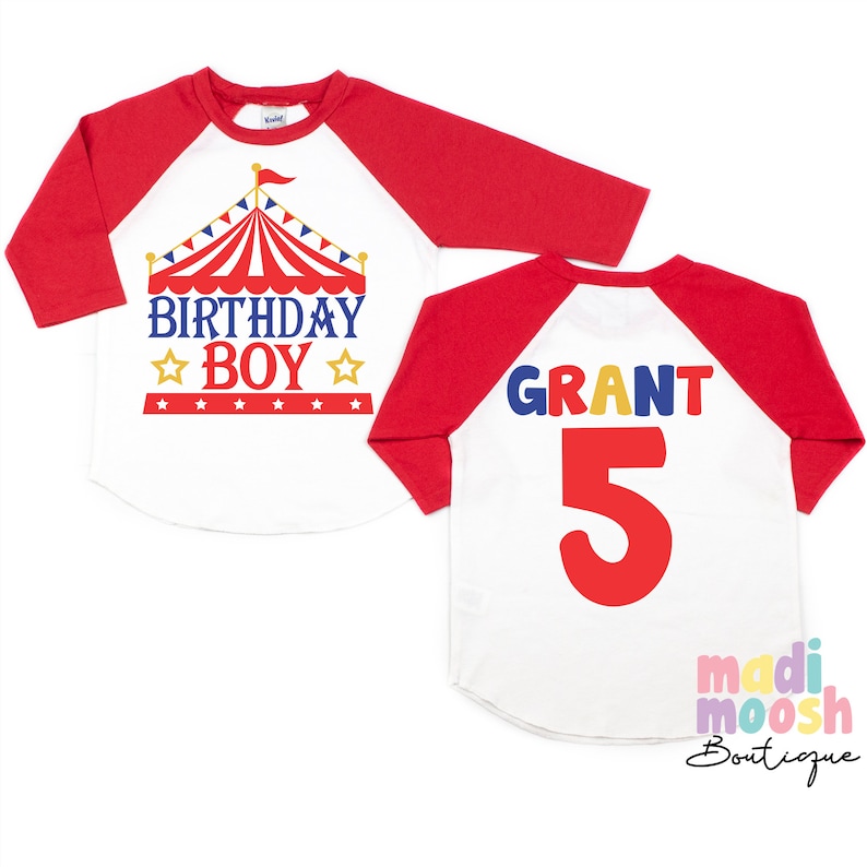 May include: Red and white baseball tee shirt with a red, white and blue circus tent graphic and the text "Birthday Boy". The back of the shirt has the name "Grant" and the number "5" in colourful letters.