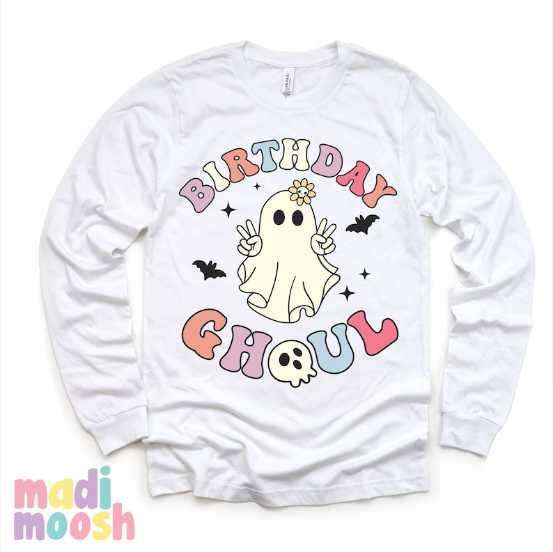 May include: White long-sleeved t-shirt featuring a colourful graphic of a ghost with a flower on its head and the text "Birthday Ghoul".