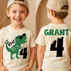May include: A cream-colored t-shirt featuring a green dinosaur wearing sunglasses and the text "Four REX 4". The back of the shirt has the name "GRANT" in green and the number "4" in black.