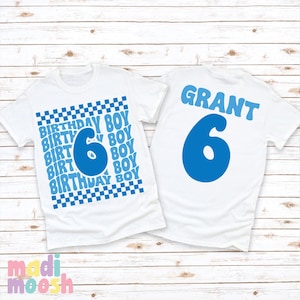 May include: Two white t-shirts with blue text and a blue number 6. The front of the shirt has a checkered pattern and the text "Birthday Boy" repeated multiple times. The back of the shirt has the name "GRANT" and the number 6.