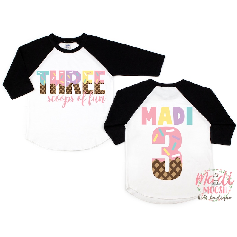 May include: Two white and black baseball shirts with ice cream cone designs. One shirt says "THREE scoops of fun" and the other says "MADI 3".