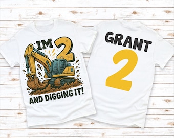 May include: Two white t-shirts. One features a yellow and blue excavator graphic with the text "I'M 2 AND DIGGING IT!". The other shirt has the name "GRANT" and a large yellow number "2".