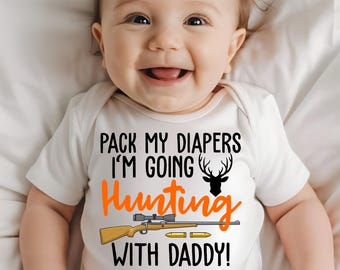 May include: White baby onesie with orange text that reads "Pack my diapers I'm going hunting with Daddy!"  A black silhouette of a deer with antlers is above the word "hunting". A cartoon rifle with orange scope and bullets is below the word "hunting".