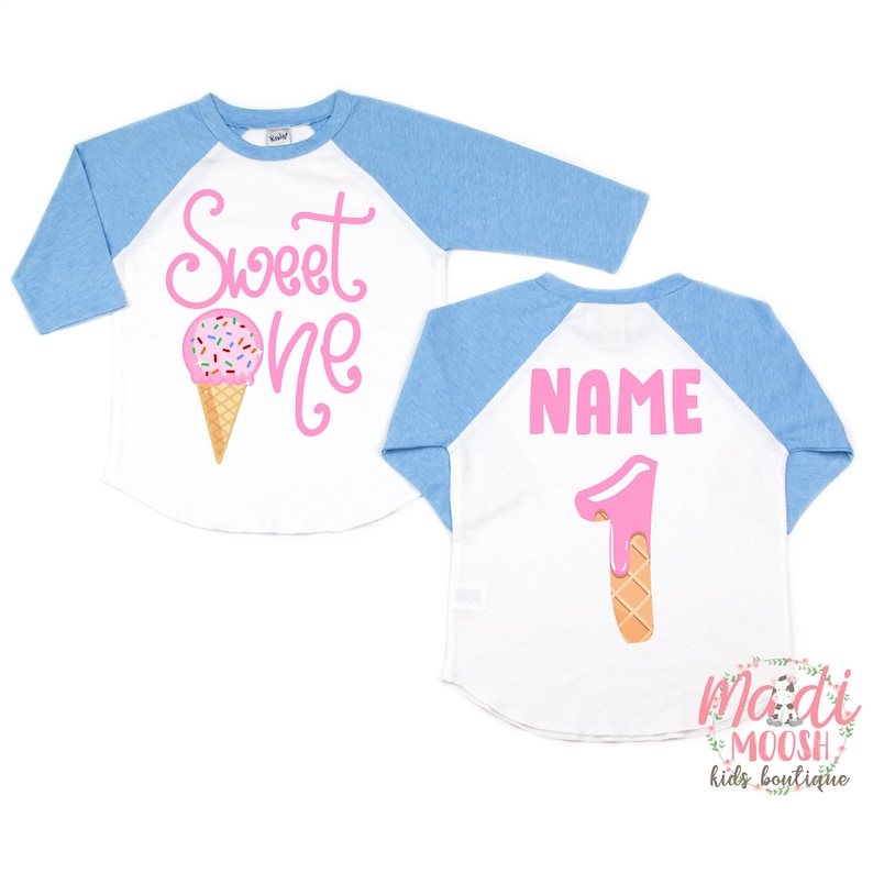 May include: A white and blue baseball style shirt with pink text that says "Sweet One" and an ice cream cone graphic on the front. The back of the shirt has the word "NAME" and a pink number one with a dripping ice cream cone graphic.