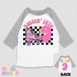 May include: White and grey baseball tee shirt with a pink roller skate and the text "Rollin' into 9" in a retro font. The back of the shirt has the text "Madi 9" in a pink and yellow font.