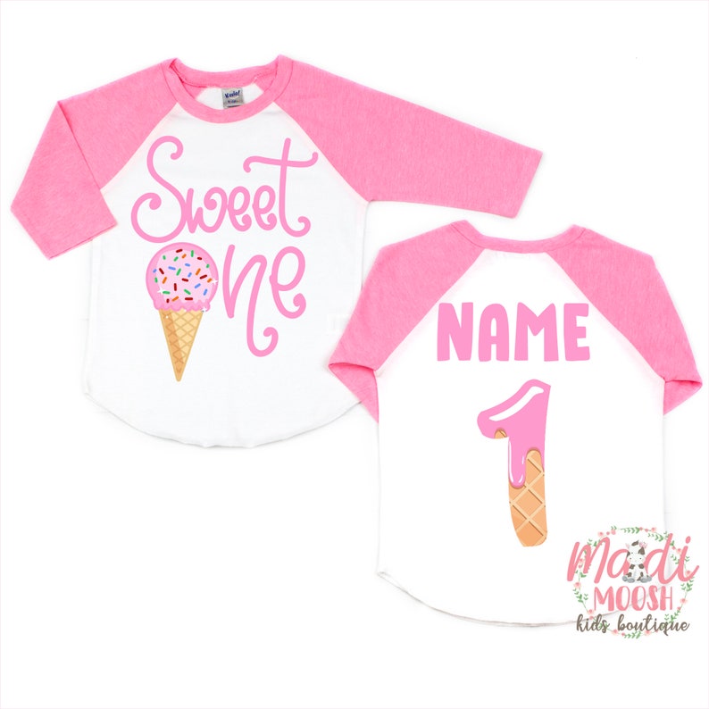 May include: Pink and white baseball tee with the text "Sweet One" and an ice cream cone graphic on the front. The back of the shirt has the text "NAME" and a pink ice cream cone number one graphic.