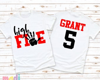 May include: White t-shirt with red text that says "high five" with a black handprint. The back of the shirt has black text that says "GRANT 5".
