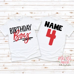 K&ouml;nnte beinhalten: Zwei wei&szlig;e T-Shirts mit schwarzem und rotem Text. Das vordere Shirt sagt "Birthday Boy" in Schwarz mit einer roten Unterstreichung. Das hintere Shirt sagt "NAME 4" in Schwarz mit einer roten Nummer 4.