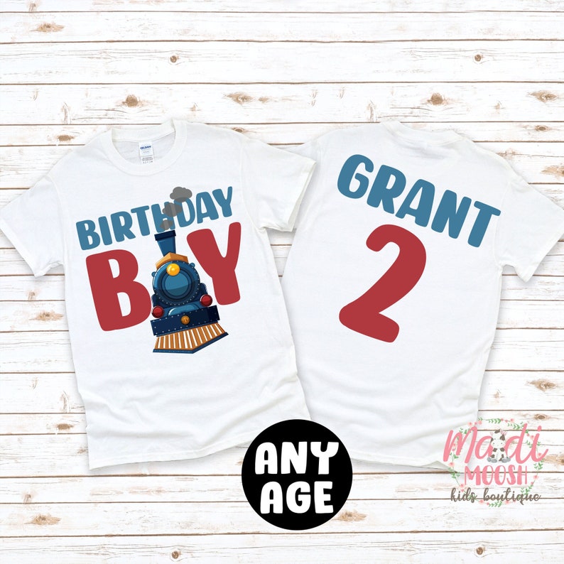 May include: White t-shirt with a blue train and the text "Birthday Boy" in red. The back of the shirt has the name "Grant" and the number "2" in red.