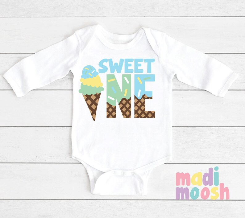 May include: White long-sleeve baby onesie with the text "SWEET ONE" in brown letters. The "ONE" is formed by an ice cream cone with blue, green, and yellow ice cream and sprinkles.