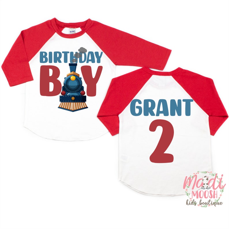 May include: Red and white baseball style shirt with a blue train and the text "Birthday Boy" on the front. The back of the shirt has the text "Grant 2" in blue and red.