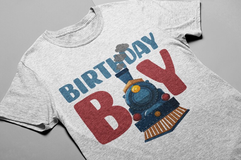 May include: A gray t-shirt with the text "Birthday Boy" in blue and red letters. A cartoon train engine is behind the "B" in the word "Boy".