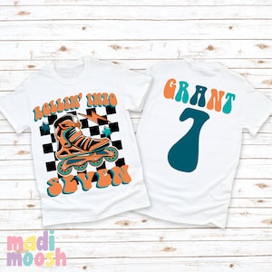 May include: Two white t-shirts with a roller skate design. The front shirt has a checkered background with a roller skate and the text "Rollin' into Seven". The back shirt has the text "Grant 7" in a retro font.