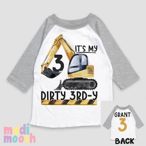 May include: A white and gray baseball style shirt with a yellow excavator design. The excavator has a black bucket and the number 3 on the side. The text "It's my dirty 3rd-y" is printed on the shirt. The back of the shirt has the name "Grant" and the number 3 in gold.
