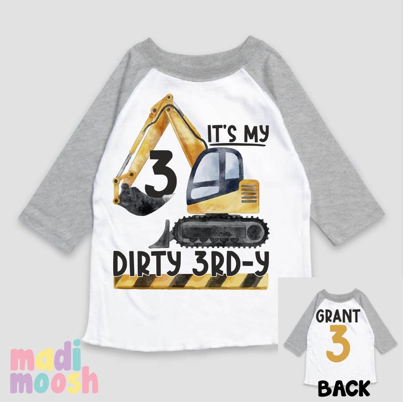 May include: A white and gray baseball style shirt with a yellow excavator design. The excavator has a black bucket and the number 3 on the side. The text "It's my dirty 3rd-y" is printed on the shirt. The back of the shirt has the name "Grant" and the number 3 in gold.