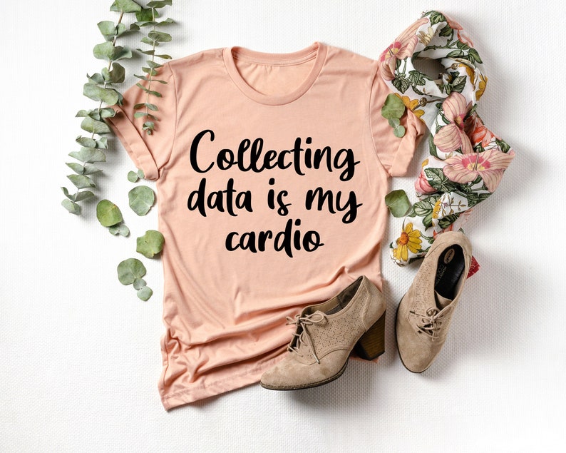 May include: A peach-colored t-shirt with the text "Collecting data is my cardio" printed in black.