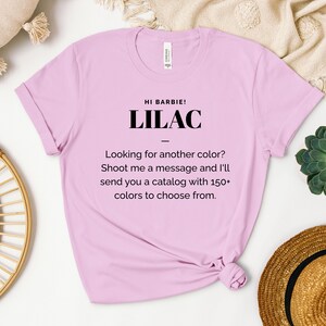 May include: A light pink t-shirt with the text "HI BARBIE! LILAC" and the message "Looking for another color? Shoot me a message and I'll send you a catalog with 150+ colors to choose from."