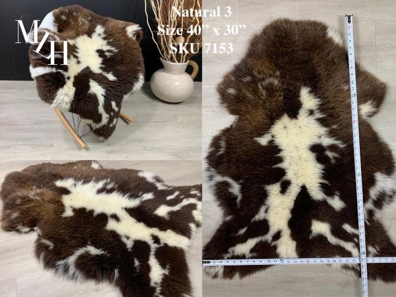May include: A brown and white sheepskin rug with a natural, mottled pattern. The rug is 40 inches by 30 inches and is labeled "Natural 3" and "SKU 7153".