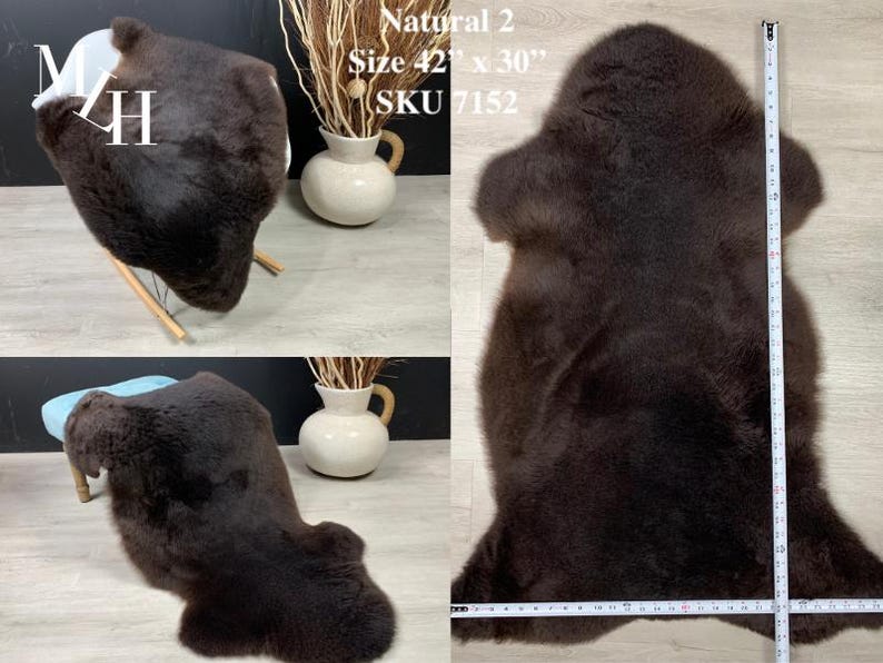 May include: A brown sheepskin rug with a natural, fluffy texture. The rug is laid out flat on a light-colored surface with a measuring tape beside it. The rug measures 42 inches by 30 inches. The text "Natural 2", "Size 42" x 30"", and "SKU 7152" is visible in the image.