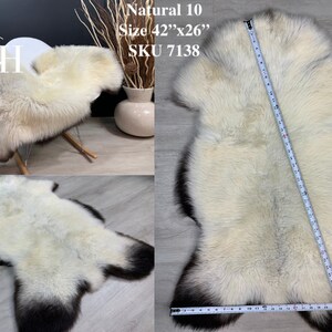 May include: Natural white sheepskin rug with a black border. The rug is 42 inches by 26 inches and has the SKU 7138.