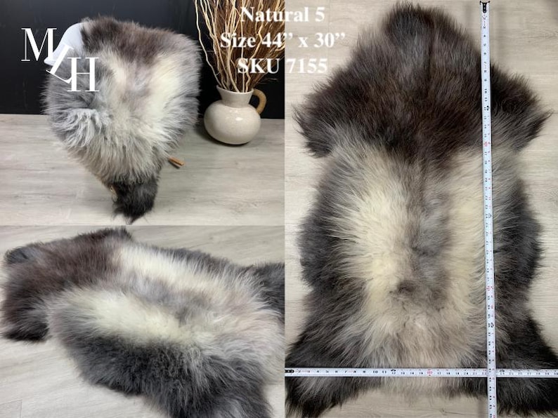 May include: A sheepskin rug with a white center and gray edges. The rug is 44 inches by 30 inches and is labeled "Natural 5" and "SKU 7155".