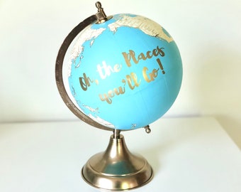Libro de visitas con globo terráqueo azul bebé pintado a mano, caligrafía dorada, ideal para bodas de viaje.