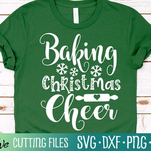 May include: Green t-shirt with white text that reads "Baking Christmas Cheer" with a rolling pin and heart graphic.