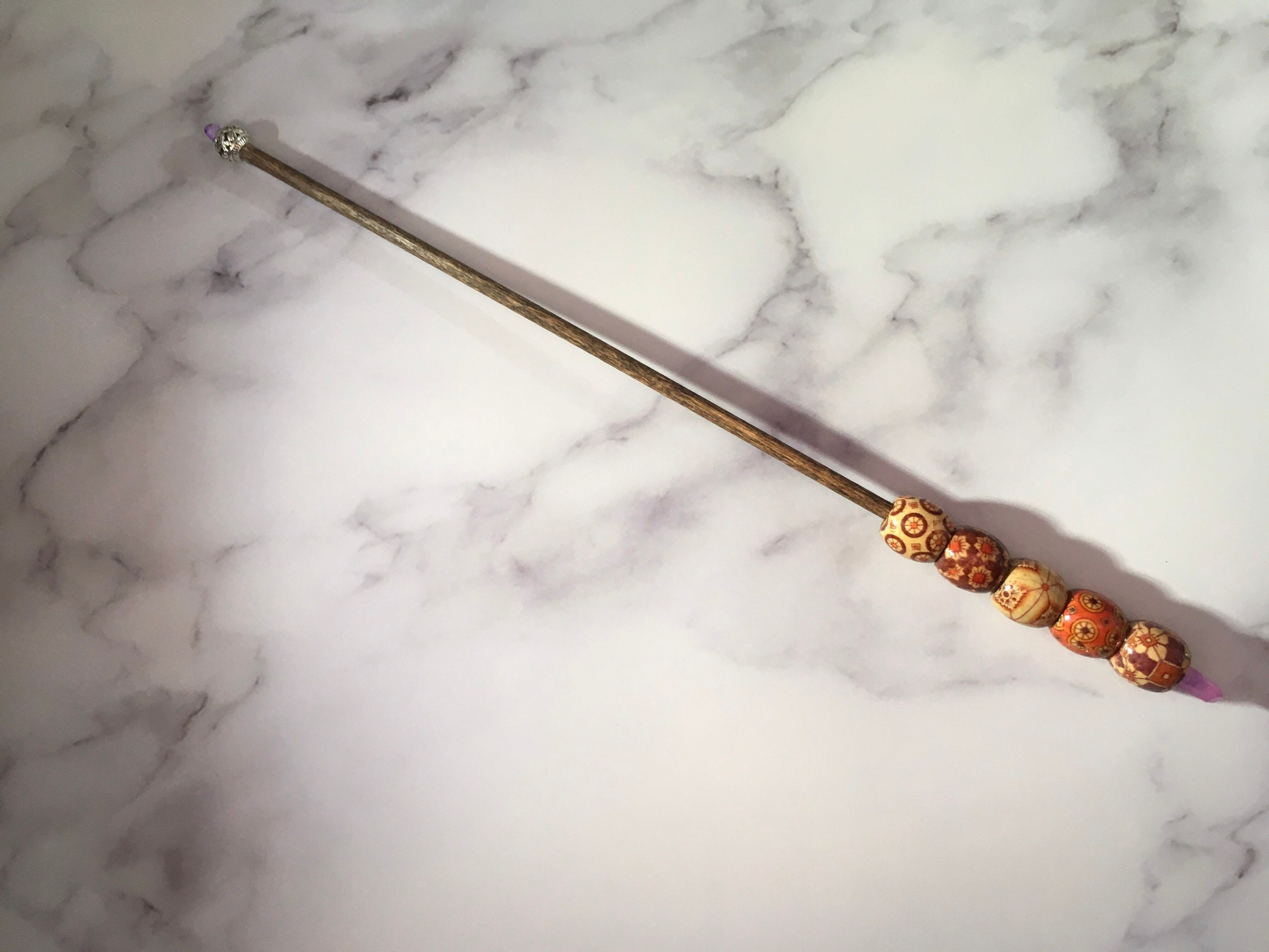 Wand with crystals and wooden beads with silver tip.
