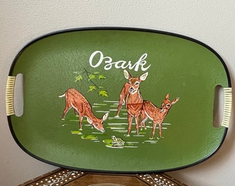 May include: A green oval serving tray with black trim and bamboo handles. The tray features a painted scene of three deer in a forest setting with the word "Ozark" written in white cursive.