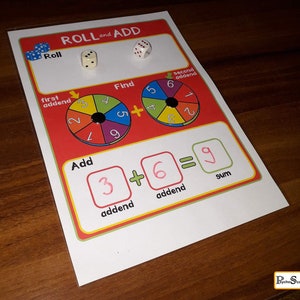 May include: A colorful learning game for kids called "Roll and Add". The game includes two dice and a spinner with numbers 1 through 9. The game teaches kids how to add numbers together.