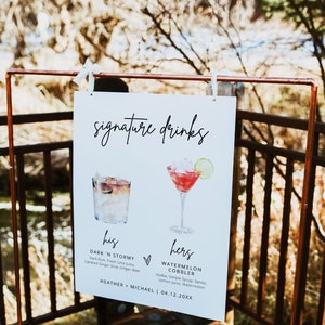 May include: A white sign with the text "signature drinks" at the top. The sign has two watercolor illustrations of cocktails, one for "his" and one for "hers". The text below the illustrations describes the ingredients for each drink. The sign also includes the names "Heather + Michael" and the date "04.12.20XX".