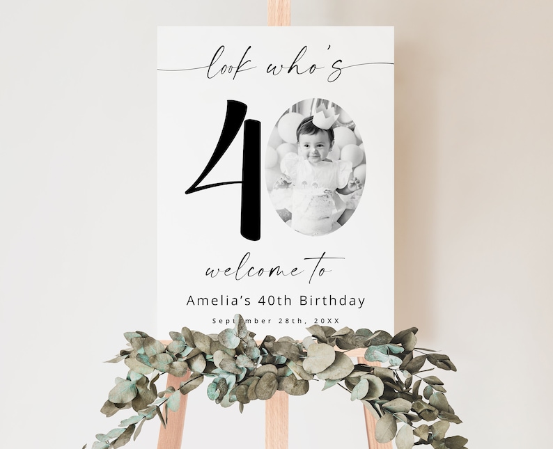K&ouml;nnte beinhalten: Ein schwarz-wei&szlig;es Willkommensschild mit der Zahl 40 in gro&szlig;er Schrift. Das Schild lautet "Look who's 40, welcome to Amelia's 40th Birthday, September 28th, 20XX". Ein Schwarzwei&szlig;foto eines kleinen M&auml;dchens befindet sich in der Mitte des Schildes.