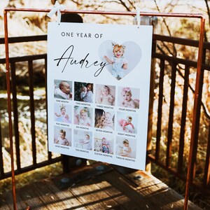 Puede incluir: Un p&oacute;ster blanco con el texto "ONE YEAR OF Audrey" en la parte superior. El p&oacute;ster est&aacute; dividido en una cuadr&iacute;cula de 12 cuadrados, cada uno con una foto de una ni&ntilde;a a diferentes edades. Las fotos est&aacute;n ordenadas cronol&oacute;gicamente, comenzando con la ni&ntilde;a de un mes de edad y terminando con la ni&ntilde;a de doce meses de edad. El texto debajo de cada foto indica la edad de la ni&ntilde;a en meses.