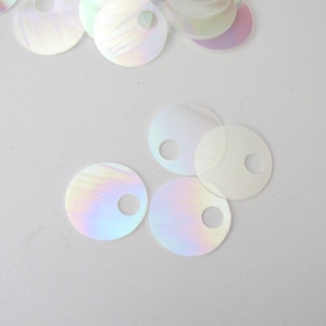 May include: Circular, iridescent sequins with a central hole. The sequins display a pearlescent effect, reflecting colours like pink, blue, and yellow. These decorative sequins are suitable for craft projects and embellishments.