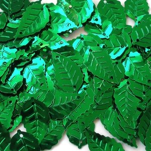 May include: A collection of shiny, emerald green leaf-shaped sequins. Each sequin has a detailed leaf vein pattern and a small hole at the top for stringing. These decorative sequins are ideal for crafts and embellishments.