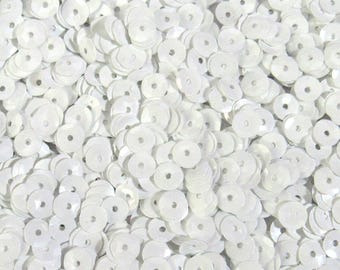May include: A close-up shot of a pile of white sequins. Each sequin is round with a hole in the center. The sequins are scattered, creating a textured surface. Ideal for crafts and embellishments.
