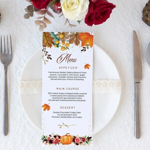 May include: A vertical rectangular menu card featuring a watercolour autumn theme with orange maple leaves, berries, and a pumpkin at the base. The text includes sections for Appetizer, Main Course, and Dessert with detailed food descriptions.