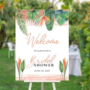 May include: Welcome to Kaitlyn's Bridal Shower sign with tropical leaves and flowers in shades of green, orange, and pink. The text reads "Welcome to Kaitlyn's Bridal Shower June 10, 2020".